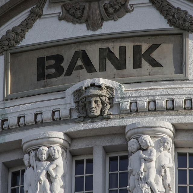 The front of a renaissance style bank with "BANK" clearly visible at the top.