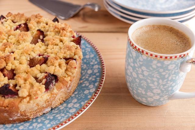 A cup of coffee and a crumble top cake on matching plate.