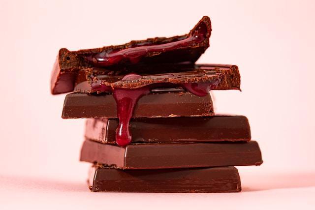 A pile of rectangle chocolate bars oozing red filling from the top.