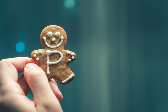 A small gingerbread man cookie with a white frosting smile and a large capital P