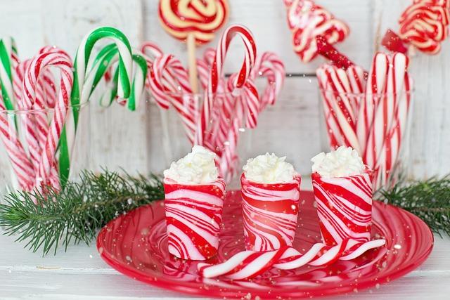 Three glasses full of candy canes and 3 candy-cane looking cups filled with whipped cream.