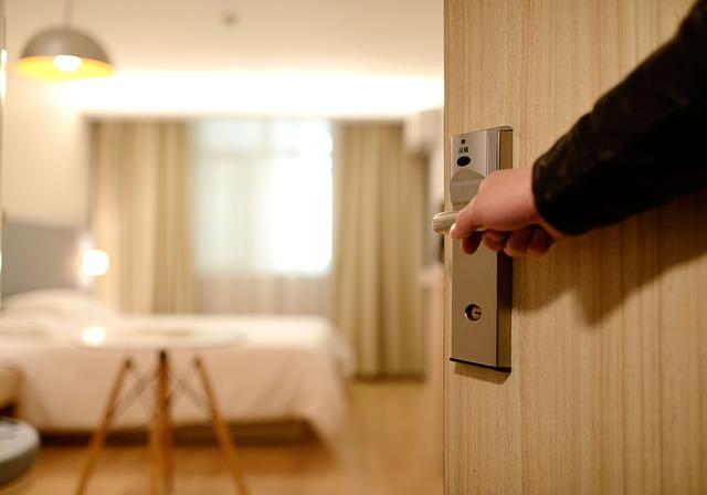 Looking into a modern, clean hotel room from the partially opened doorway.