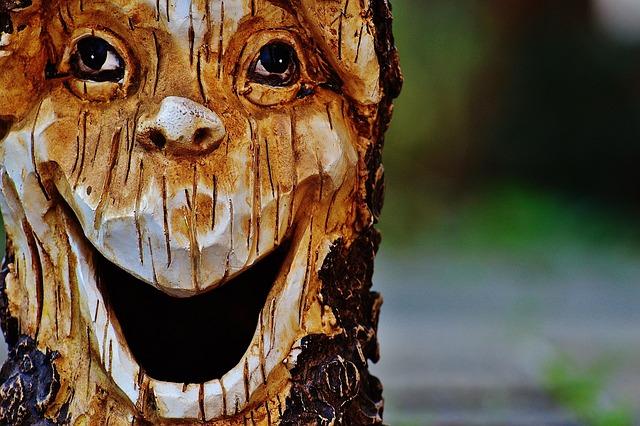 A tree stump carved to look like it is laughing.