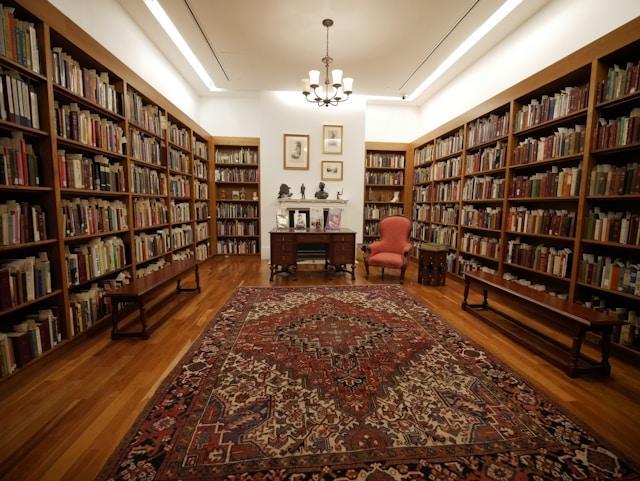 It's like we're standing at the door of a library room with books floor to ceiling on 3 walls, and a Turkish rug on the floor.