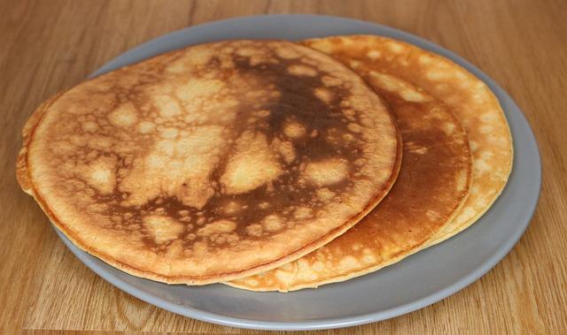 Two large pancakes on a grey plate waiting for butter and syrup.