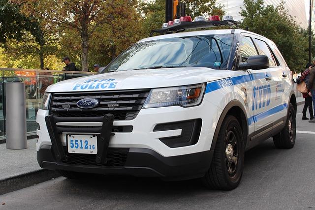 A bumper level view of a NYPD police Ford Bronco parked at the side of a city street.