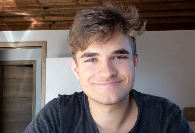 A smiling teen boy looking directly at us.