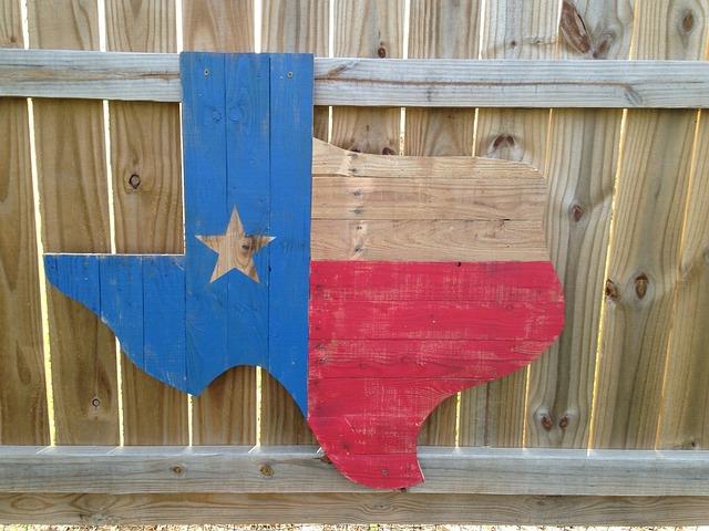 A wooden outline of the state with the flag colors attached to a wooden fence