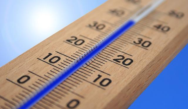 A wooden thermometer with blue fluid against what might be a sky background showing 40 degrees.