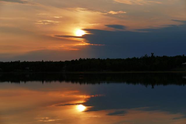 Golden hour during sunset over a lake reflecting the beauty of an orange sky.