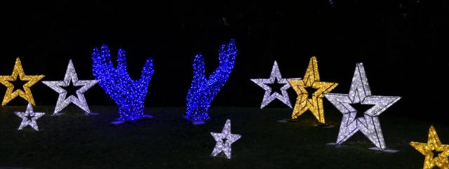 Silver and gold star, and large blue hand light shapes displayed against a black background.