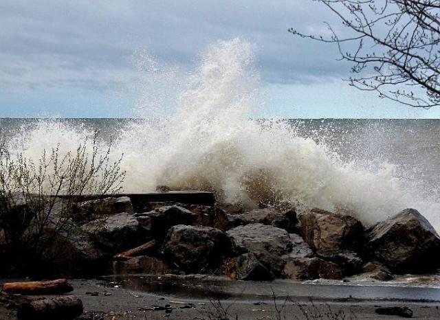 A wave crashing over a rocky outcropping near the shore of Lake Ontario.