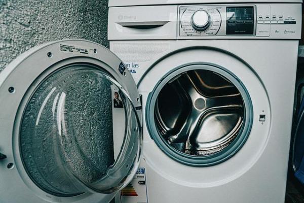 Front-loading washing machine with door open and control panel visible.