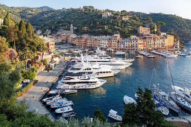 A birds-eye view of the harbour in Portofino Italy filled with numerous luxury yachts.