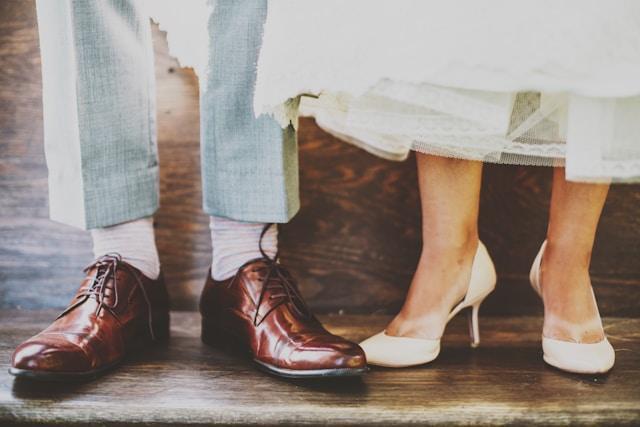 An image of feet dressed in fancy dress shoes of a couple who are obviously dressed up.