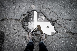 Looking at the reflection of a plan flying overhead in a puddle at your feet.
