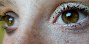 A close-up of someone's eyes, a hazel green and grey color.