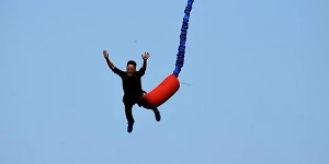 A man bungee jumping with only the rope, the sky and a terrified man falling in view.