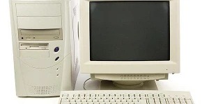 A computer screen, keyboard and tower from the 1990s.