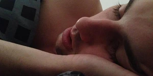 A close-up of the face of a man asleep in bed.