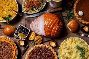 Thanksgiving food up close, sliced ham, potatoes, pies and more.