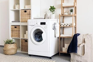 A tidy laundry room with a white washing machine and 2 tidy shelving units on either side of it.