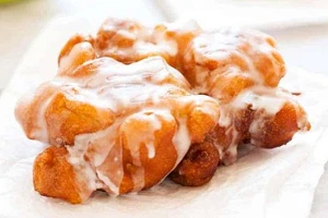 A large apple fritter on a plate.