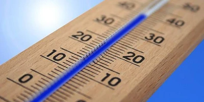 A wooden thermometer with blue fluid against what might be a sky background showing 40 degrees.