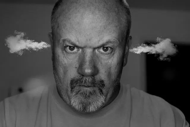 Black and white photo of an angry man with steam coming out of his ears looking directly at us.