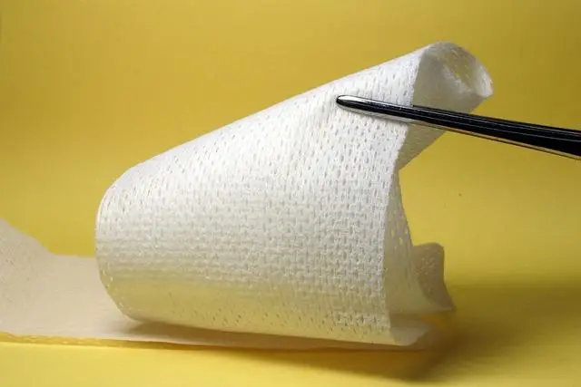 a length of 4 inch wide gauze unrolled with scissors ready to cut