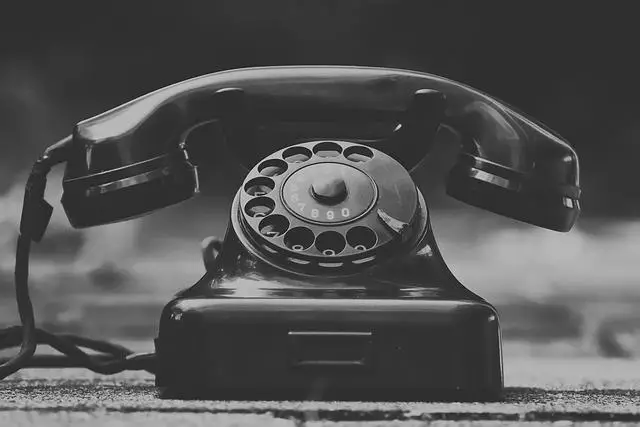 A vintage black rotary phone.