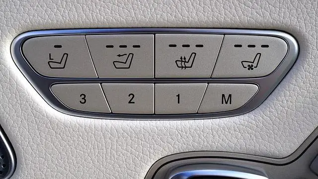 The console of a Mercedes showing the buttons for heated seats.