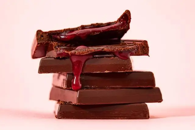 A pile of rectangle chocolate bars oozing red filling from the top.