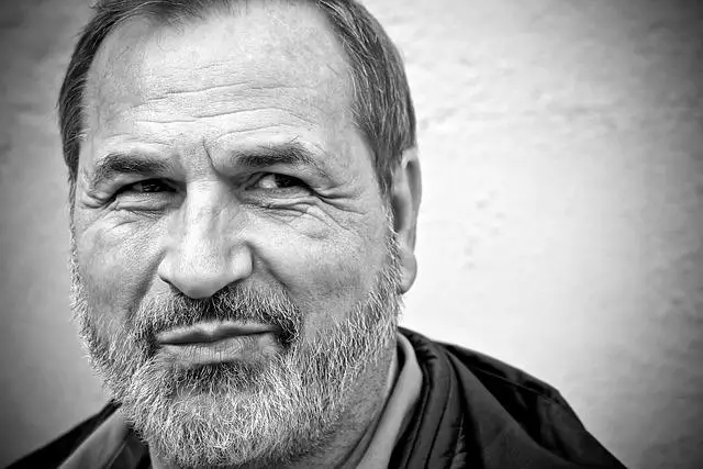 A black and white image of a middle-aged man with a short beard looking off to the side.